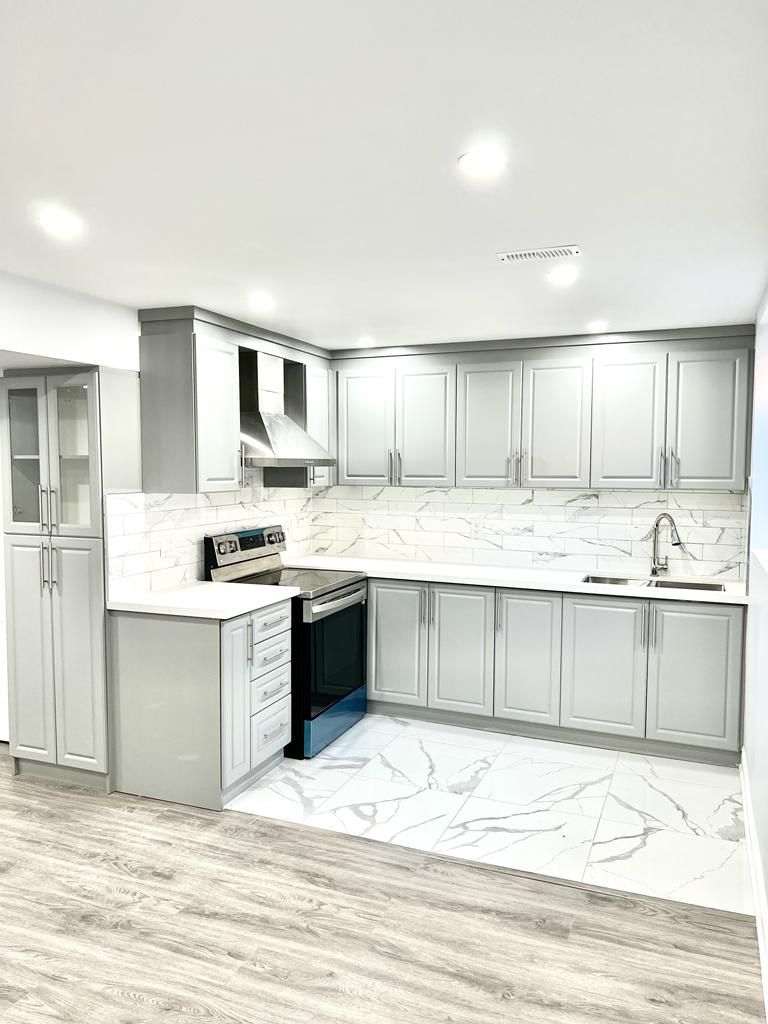 Bright tailored kitchen by Aim Baaaz Builders